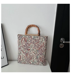 Detail of vintage floral jacquard tote bag featuring decorative bamboo handles