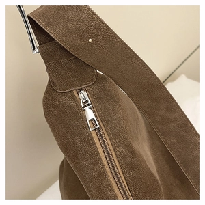Detail of dark brown leather tote with silver zipper and reinforced wide shoulder strap