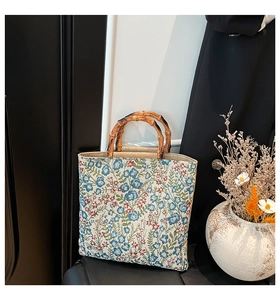 Close-up of floral tote bag with natural bamboo U-shaped handles in an elegant setting