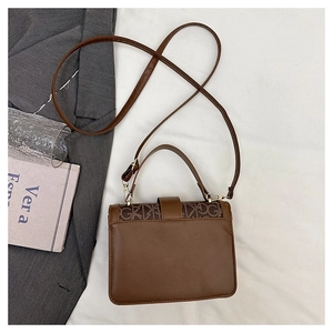 Vue détaillée du sac en similicuir marron foncé avec motifs vintage et garnitures dorées