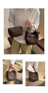 Detail of dark brown lychee leather bucket bag with silver twist lock and inner pouch