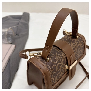 Détail d'un sac Boston à monogramme marron avec ferrures dorées et bandoulière en cuir