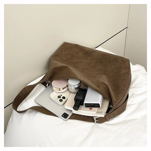 Spacious brown suede hobo bag storing laptop and essentials for daily commute