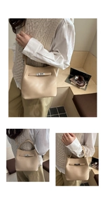 Detailed view of beige lychee leather bucket bag with silver metal swivel buckle