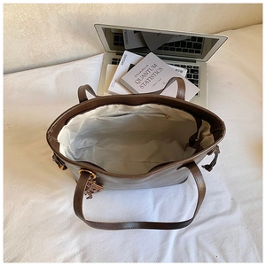 Interior view of brown leather tote bag showing spacious lining and zipper pocket
