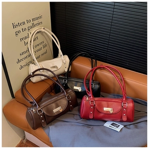 Detail of bolster handbags in white, black, brown and red with heart-shaped metal buckles