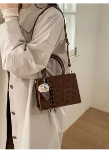 Detail of leopard print handbag with plush ice cream charm and detachable strap