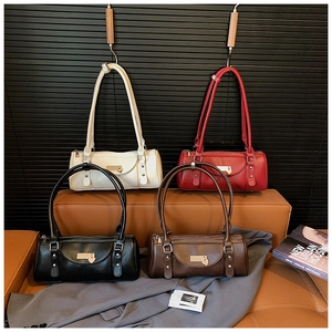 Détail de quatre sacs Boston en cuir de diverses couleurs avec breloques en forme de cœur