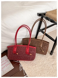 Macro shot of faux suede leopard print tote bag with knotted strap and gold hardware detail