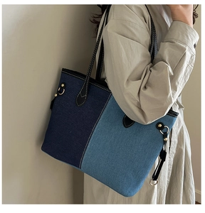 Detail of blue denim patchwork tote bag with contrast stitching and leather handles