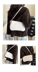 Dettaglio di una borsa baguette bianca minimalista in pelle con tracolla regolabile