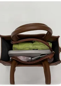 Top view of brown leather bag interior showing spacious capacity for umbrella and phone