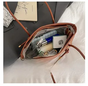 Top view of the interior compartment of a brown leather tote bag with daily essentials