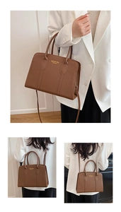 Detailed macro view of the brown crocodile pattern texture and golden logo on handbag