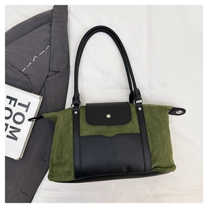 Detail of vintage patchwork handbag in olive green suede and black leather with metal buckle