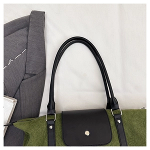 Close-up of green suede and black leather patchwork tote with silver metal hardware