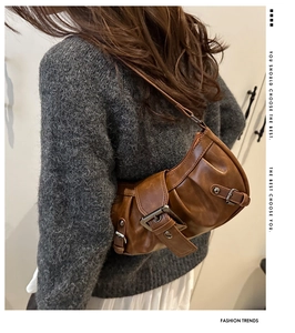 Detailed close-up of brown vintage shoulder bag with textured oil wax leather finish