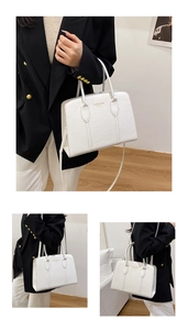 Detail showing white croc-embossed texture and fashion bag NEW YORK text on handbag