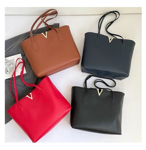 Flat lay of tote bags in four colors with gold V hardware and lychee grain leather texture