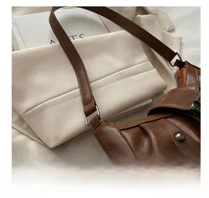 Detail view of vintage brown PU leather shoulder bag with metallic ring and pleated design