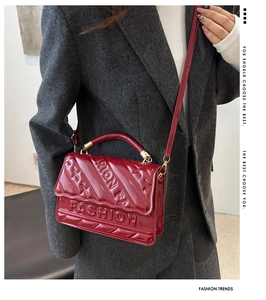Detail of red patent leather handbag with diamond stitching and embossed FASHION lettering
