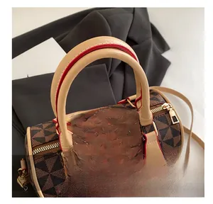 Close-up of brown geometric pattern Boston bag with gold hardware and leather handles