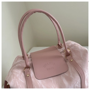 Close-up of pink large travel tote bag featuring crinkle texture fabric and gold hardware