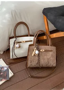 Détails de sacs à main trapèze rétro avec motifs verticaux et fermoir tournant en métal