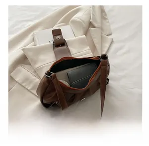 Macro shot of large capacity brown pleated shoulder bag showing spacious interior space