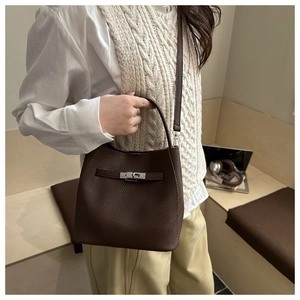 Close-up of brown lychee grain leather bucket bag with silver metal swivel lock