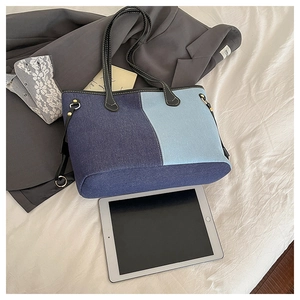 Large denim patchwork tote bag showing interior capacity with a tablet and notebook