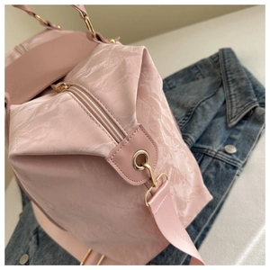 Detail of pink pleated fabric bag texture with light gold metal zipper and fabric strap