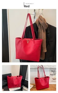 Close-up of red tote bag with litchi texture leather and golden metal V logo