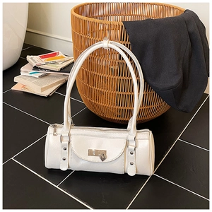 Détail d'un sac bowling en cuir blanc avec pendentif cœur et finitions argentées