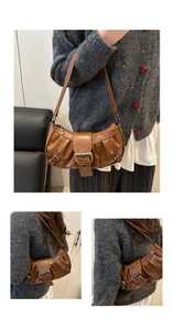 Brown vintage pleated underarm bag with silver buckle and shoulder strap in detail