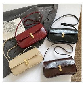 Flat lay of four vintage glossy leather shoulder bags with gold locks and slim straps