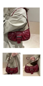 Detail view of red vintage leather shoulder bag with metallic buckle and retro texture