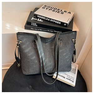 Close-up of contrast stitching on denim texture tote bag with leather trim details