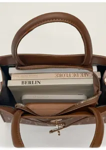 Vertical view of brown leather tote bag interior showing capacity for books and phone