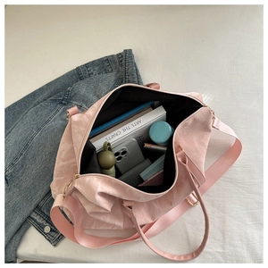 Pink travel bag interior showing large capacity for phone, wallet, and water bottle