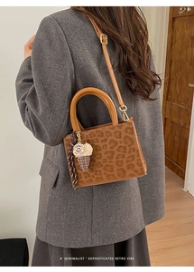 Detail of leopard print handbag texture with a cute ice cream charm on the brown handle