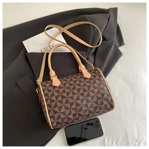 Detail view of the geometric pattern Boston bag with red edge paint and gold metal hardware