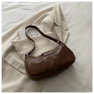 Detailed texture of retro dark brown PU leather on a minimalist crescent underarm bag