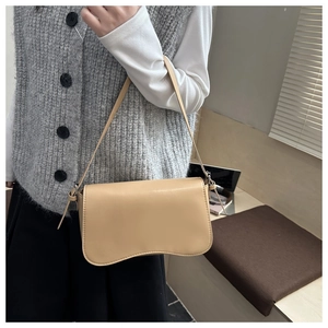 Dettaglio della borsa baguette beige minimalista con base ondulata e pelle PU liscia di lusso