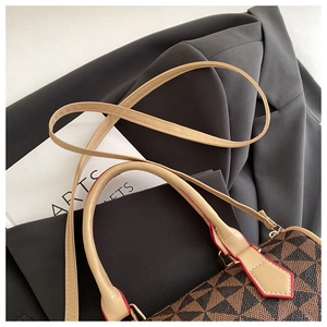 Detail of geometric pattern shoulder bag with light leather handles and red edge oil