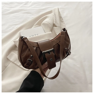 Detail of vintage brown tote bag with pleated texture and a large square metal buckle