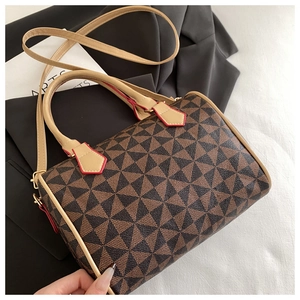 Detail of Boston bag with geometric prints, white leather handles, and red edge paint