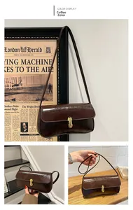 Detail of coffee brown glossy leather baguette bag with elegant golden metal twist lock
