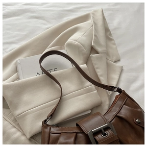 Detail of vintage pleated dark brown shoulder bag with a square metal buckle clasp