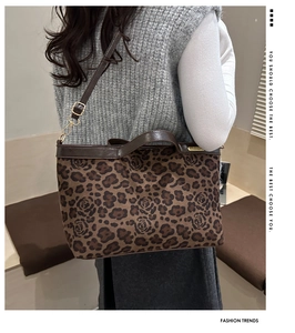Detail showing side view of leopard print tote bag with adjustable shoulder strap and gold hardware